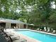 Community pool with lounge chairs and a surrounding wooded area, ideal for relaxation and recreation at 3527 Essex Ave # 74, Atlanta, GA 30339