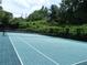 Community tennis court with green surface, net, and a wooded surround at 3527 Essex Ave # 74, Atlanta, GA 30339