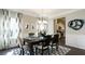 Elegant dining room features dark hardwood floors, black table and chairs, and wainscoting and opens to kitchen at 524 Lanier Way, Temple, GA 30179