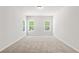 Spacious bedroom featuring neutral carpet, white walls, and two windows at 897 Porches Way, Dacula, GA 30019