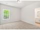 Well-lit bedroom featuring neutral carpet, and a window looking onto wooded yard at 897 Porches Way, Dacula, GA 30019