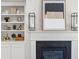 Close up of a black fireplace with white mantle, flanked by built-in bookshelves and modern decor at 897 Porches Way, Dacula, GA 30019