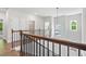 Second floor foyer featuring decorative light fixture, hardwood floors and staircase with metal balusters at 897 Porches Way, Dacula, GA 30019