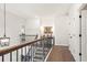 Bright hallway with hardwood floors, decorative lighting, and wooden banister staircase at 897 Porches Way, Dacula, GA 30019