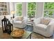 Bright living room showcasing two swivel chairs, nature-inspired decor, and large windows with wooded views at 897 Porches Way, Dacula, GA 30019