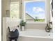 Bathroom close up of soaking tub and outside view to a private backyard at 897 Porches Way, Dacula, GA 30019