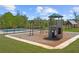 Community playground and pool featuring a playset, swings, and a neighboring pool surrounded by green grass at 897 Porches Way, Dacula, GA 30019