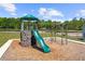 Community playground featuring a slide, climbing structure, and swings, set on a wood-chip surface at 897 Porches Way, Dacula, GA 30019