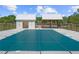 Community pool with a safety cover, adjacent to a pool house and covered seating area, surrounded by fencing at 897 Porches Way, Dacula, GA 30019