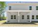 Rear exterior of home featuring a covered patio, white siding, manicured lawn, and mature trees at 897 Porches Way, Dacula, GA 30019