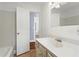 Bright bathroom featuring tiled walls and floors with a white vanity and an open door to another room at 135 Adair Se Ave, Atlanta, GA 30315