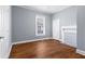 Bedroom with hardwood floors, a large window, white trim, and a decorative fireplace at 135 Adair Se Ave, Atlanta, GA 30315