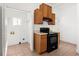 Kitchen with wood cabinets, black appliances, tile flooring, and a laundry area to the side at 135 Adair Se Ave, Atlanta, GA 30315