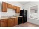 Kitchen featuring wood cabinets, a black refrigerator, and a window providing natural light at 135 Adair Se Ave, Atlanta, GA 30315