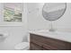 Charming bathroom features a modern vanity, round mirror, and a tiled shower at 674 Valleyview Dr, Forest Park, GA 30297