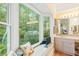 Bright bathroom featuring a bay window with nature views, neutral countertops, and a mounted television at 6791 Yacht Club Dr, Acworth, GA 30102