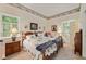 Cozy bedroom featuring decorative wall trim, windows with shutters and unique floral bedspread at 6791 Yacht Club Dr, Acworth, GA 30102