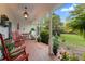 Cozy covered front porch featuring rocking chairs, lush greenery, and a welcoming atmosphere at 6791 Yacht Club Dr, Acworth, GA 30102