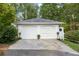 Two-car garage with white doors complemented by potted plants and exterior lights at 6791 Yacht Club Dr, Acworth, GA 30102