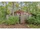 Rustic outbuilding with a wooden fence, surrounded by lush greenery and mature trees at 6791 Yacht Club Dr, Acworth, GA 30102