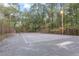 Outdoor fenced tennis court with lighting surrounded by trees at 6791 Yacht Club Dr, Acworth, GA 30102