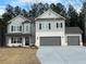 New two-story home with gray siding, brick base, and a three-car garage at 2769 Porches Ln, Dacula, GA 30019