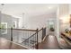 Second story hallway with hardwood floors and a view through to a sunlit room at 2769 Porches Ln, Dacula, GA 30019