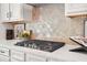 Close-up of modern gas range with neutral tiled backsplash in updated kitchen at 2769 Porches Ln, Dacula, GA 30019