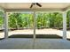 Large patio with white columns and a ceiling fan overlooks a lush wooded backyard at 2769 Porches Ln, Dacula, GA 30019