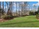 Lush green backyard with mature trees and well-manicured shrubs at 406 Greyfield Dr, Canton, GA 30115