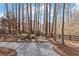 Secluded backyard gravel area with mature trees, stone bench, and whimsical decorations at 406 Greyfield Dr, Canton, GA 30115