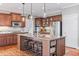 Large kitchen with hardwood floors, granite island with seating, and pantry doors at 406 Greyfield Dr, Canton, GA 30115