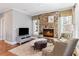 Comfortable living room features a stone fireplace, large windows, and cozy seating for a relaxed atmosphere at 406 Greyfield Dr, Canton, GA 30115