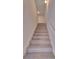 Carpeted staircase featuring white risers and stringers and a handrail with two overhead light fixtures at 425 Camella Cir, Mcdonough, GA 30252