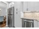 Bright kitchen area with stainless steel refrigerator, white cabinets, and decorative backsplash at 1506 Country Park Se Dr, Smyrna, GA 30080