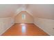 A bright attic featuring hardwood floors, natural lighting, and built in storage in the walls at 190 The Falls Blvd, Covington, GA 30016
