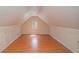 Long attic with wooden floors, one window, and storage at 190 The Falls Blvd, Covington, GA 30016