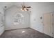 Neutral bedroom with a ceiling fan and large arched window at 190 The Falls Blvd, Covington, GA 30016