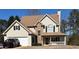 Charming two-story home with light siding, stone accents, covered porch, and attached garage at 190 The Falls Blvd, Covington, GA 30016