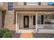 Inviting front porch with stacked stone accents, a 'Welcome' mat, and ADT security sign at 190 The Falls Blvd, Covington, GA 30016