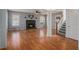 Open-concept living room with hardwood floors, fireplace, and stairway access at 190 The Falls Blvd, Covington, GA 30016