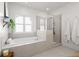 Bright bathroom featuring a soaking tub and glass-enclosed shower at 2042 Drew Dr, Atlanta, GA 30318