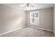 A basic bedroom view features carpeted floors, neutral colored walls, and a window view at 3265 Newcastle Way, Snellville, GA 30039