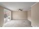 Spacious living room featuring neutral walls, carpet floors, ceiling fan, and sliding glass door at 3265 Newcastle Way, Snellville, GA 30039