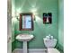 Bathroom featuring pedestal sink, toilet, art, and green paint at 6000 E Andechs Smt, Johns Creek, GA 30097