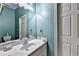 Bright bathroom featuring a white vanity with sink, a large mirror, and light blue wall paint at 6000 E Andechs Smt, Johns Creek, GA 30097