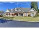 Exterior shot of the home, featuring its brick facade, manicured lawn, and well-maintained landscaping at 6000 E Andechs Smt, Johns Creek, GA 30097