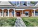 Elegant brick facade with a covered entrance and well-maintained lawn, creating a welcoming approach at 6000 E Andechs Smt, Johns Creek, GA 30097