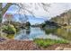 Wide view of the community pond with mature trees and upscale houses as a serene backdrop at 6000 E Andechs Smt, Johns Creek, GA 30097