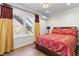 Bedroom featuring wood floors, a large window with natural light, and a bed with red patterned bedding at 7335 Treyland Ct, Cumming, GA 30041